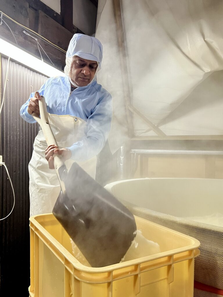 Ravi Joshi shovelling steamed rice in a Sake brewery 
