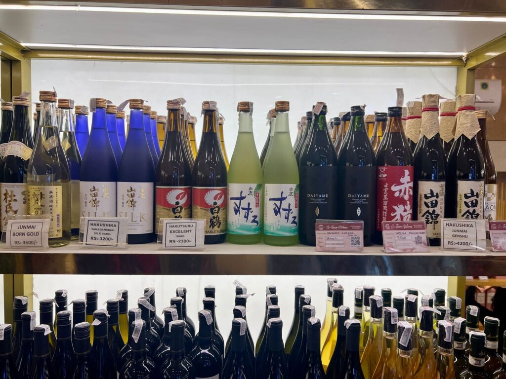 Sake and shochu bottles lined up on a retail shelf in India